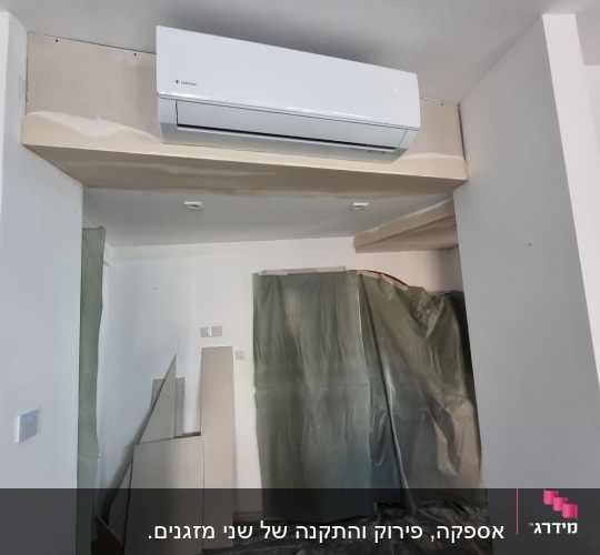 מזגן מותקן על קיר בחדר עם יריעות פלסטיק